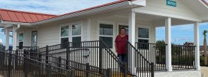 Image of Tangie Horton standing on the front porch of our new RV Park Office.